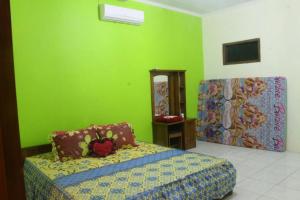巴图卡拉Sederhana Homestay的一间卧室设有一张床和绿色的墙壁