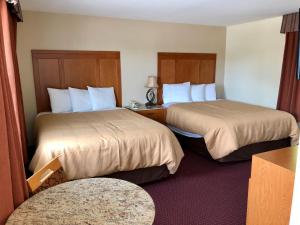 亨茨维尔亨茨维尔旅馆的酒店客房设有两张床和一张桌子。