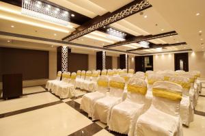 纳威孟买Hotel Vista Inn的一间设有一排椅子和白色床单的房间