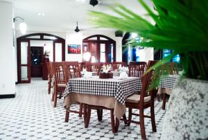 芹苴南波精品酒店的一间带桌子和木椅的用餐室
