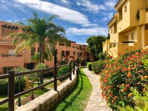 马贝拉Apartamento Guadalmina - Golf & Playa - Marbella的穿过城市的步行道,那里有建筑和鲜花