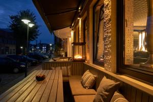 胡苏姆托马斯时尚温泉酒店的坐在建筑物边的木凳