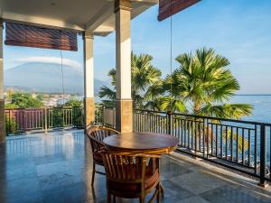 艾湄湾艾湄湾海滩别墅酒店的俯瞰大海的阳台配有桌椅