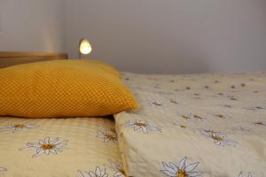 萨斯阿尔马格尔Haus Mondelli的一张带黄色枕头的床,上面有鲜花