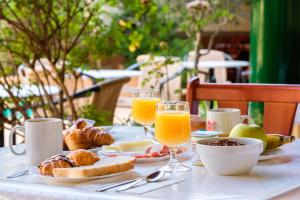 罗萨斯Hostal ROM Familiar的一张桌子,上面有早餐食品和橙汁