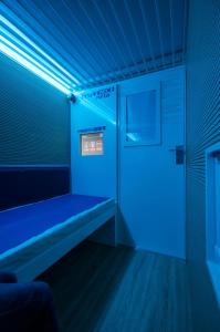 贝加莫Resting Pods - ZzzleepandGo BGH Bergamo Hospital的一间蓝色的房间,在一扇门的房间里设有长凳