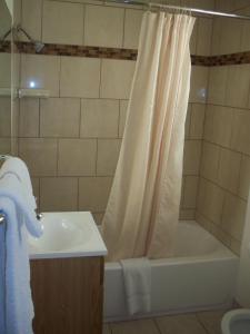 罗斯威尔Deluxe Inn Of Roswell的浴室配有淋浴帘、浴缸和盥洗盆。