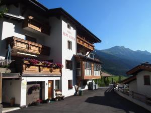圣安东阿尔贝格Quality Hosts Arlberg - Haus Pepi Eiter的白色的建筑,设有木制阳台和鲜花
