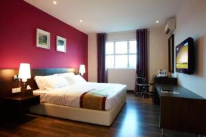 甘榜龙溪D精品酒店的一间卧室设有一张床和红色的墙壁