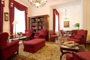 库塔斯海尔特莱卡斯特酒店的客厅配有红色椅子和桌子