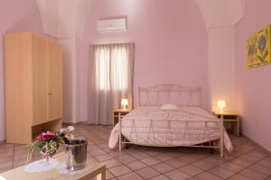 乌真托Le Dimore dei Messapi的一间卧室设有床、两张桌子和一扇窗户