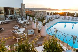 巴哈撒丁岛格兰德雷勒德努拉盖酒店的一个带游泳池和带椅子的甲板的度假村