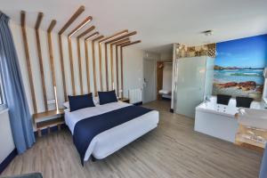 卡马里尼亚斯Playa de Camariñas的一间带大床的卧室和一间浴室
