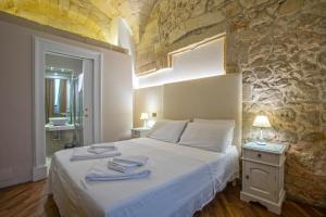 莱切Chiesa Greca - SIT Rooms & Apartments的一间卧室配有带毛巾的床