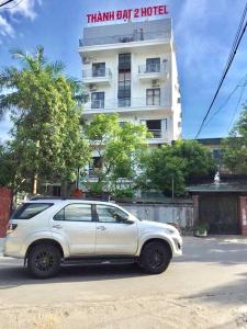 荣市Thanh Dat 2 Hotel的停在大楼前的白色汽车