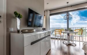米兹多洛杰Apartament Prestige & Sea Horyzont 613的客厅配有电视和桌椅