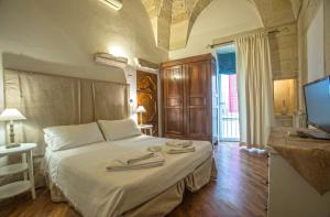 莱切Chiesa Greca - SIT Rooms & Apartments的一间卧室配有一张床,上面有两条毛巾