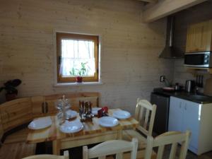 乌斯特卡Agroturystyka nad Morzem的一间带木桌和椅子的厨房以及一间用餐室