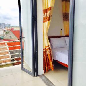 荣市Thanh Dat 2 Hotel的一间设有一张床的客房和一个带窗户的玻璃门