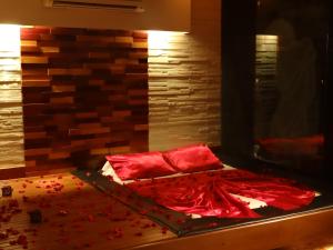 多拉杜斯Delirio Moteis Pousada的一张铺有红色床单和红色枕头的床