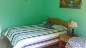 姆巴巴内Otentik guesthouse的绿色墙壁间的一张床位