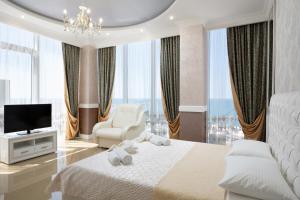 阿德勒Tropicana Resort Hotel Sochi的一间卧室配有一张床、一台电视和一把椅子