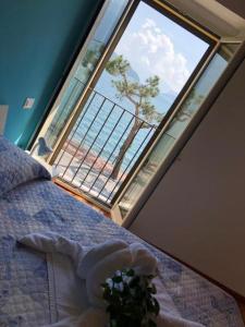 多马索Hotel Mojito的卧室设有大窗户,床上种植了植物