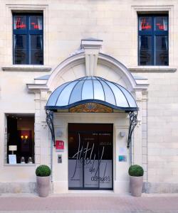 索米尔The Originals Boutique, Hôtel Le Londres, Saumur (Qualys-Hotel)的蓝色遮阳篷建筑前的商店