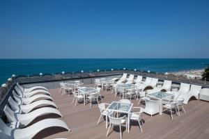 阿德勒Tropicana Resort Hotel Sochi的甲板上的一排桌椅