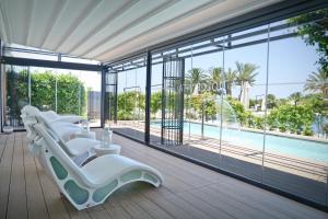 奥斯图尼玛赛丽亚圣塔卢西亚大酒店的一间设有白色躺椅的房间和一个游泳池