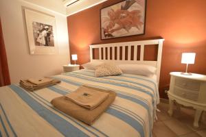 洛科罗通多Villa Petra Chiara的一间卧室配有带毛巾的床