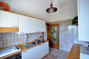 洛科罗通多Villa Petra Chiara的厨房配有白色橱柜和水槽