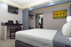 奥里萨巴哈酒店的一间卧室配有一张床和一张带笔记本电脑的书桌