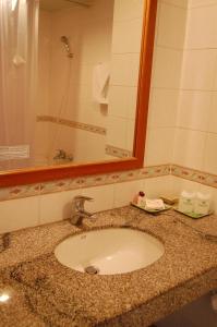 清迈皇家兰娜酒店的浴室的柜台设有水槽和镜子