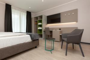 加尔达湖滨Garda Life的一间卧室配有一张床、一张桌子和一把椅子