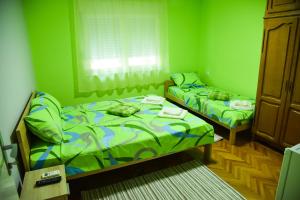 尼什PRENOĆIŠTE PILOT的绿墙客房内的两张床