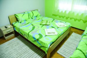 尼什PRENOĆIŠTE PILOT的一间卧室配有一张带绿色棉被的床