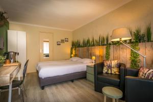 HulsbergCarré Hotel Zuid-Limburg的酒店客房带一张床、一张桌子和椅子