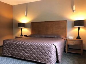 西沃德微风汽车旅馆的一间卧室配有一张大床和两盏灯。