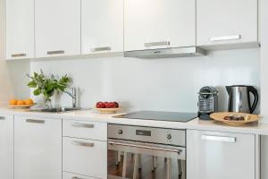 巴塞罗那Glasir Apartments Barcelona的白色的厨房配有白色橱柜和水槽