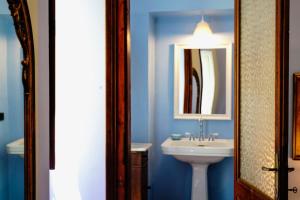 卡洛福泰Sofia Family Suites的蓝色的浴室设有水槽和镜子