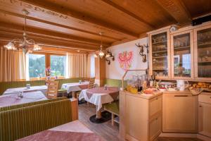 盖洛斯Pension Alpengruss的一间带2张桌子的餐厅和一间用餐室