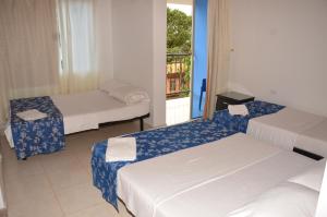 洛佩斯港Hotel Bahía Cadi的带三张床和窗户的客房