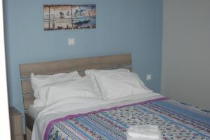 内亚卡瓦里Soula's Sunshine Apartments的一间卧室配有一张带木制床头板的床