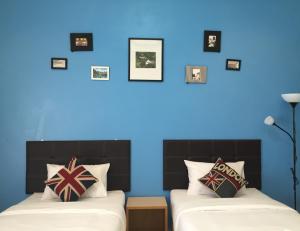 乌汶乌汶佳地公寓的蓝色墙壁客房的两张床