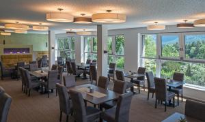 毛拉赫Arthur's Hotel und Apartments am Achensee的用餐室设有桌椅和窗户。