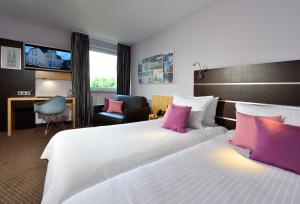 科隆胡加尔尼高级酒店的酒店客房配有一张带粉红色枕头的大床