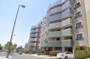 艾卜哈New Abha Resort的一座大型公寓楼,前面设有停车场