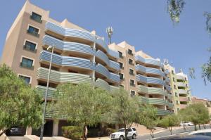 艾卜哈New Abha Resort的一座大型公寓楼,前面设有停车场