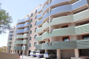 艾卜哈New Abha Resort的大型公寓楼设有蓝色和白色阳台